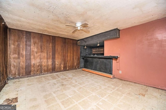 interior space featuring wood walls and ceiling fan