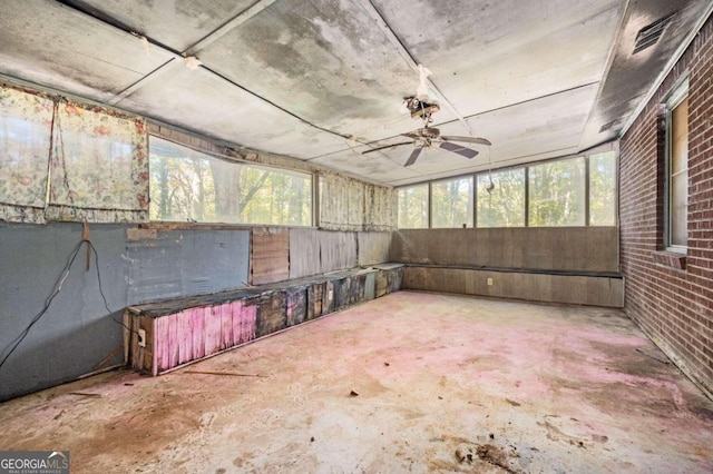 unfurnished sunroom with a healthy amount of sunlight and ceiling fan