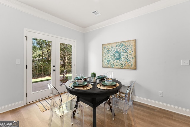 dining space featuring french doors, wood-type flooring, and ornamental molding