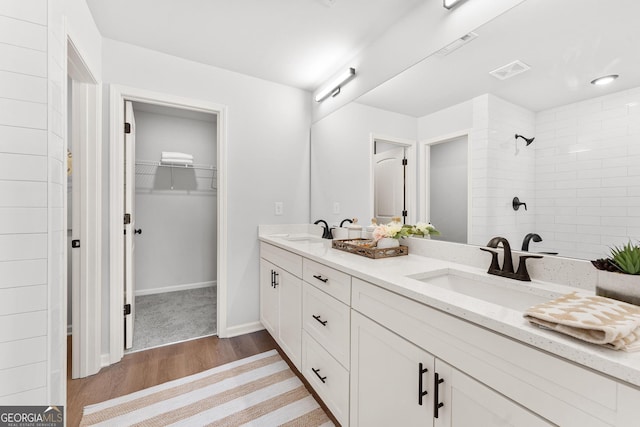 bathroom featuring vanity, a tile shower, and hardwood / wood-style flooring