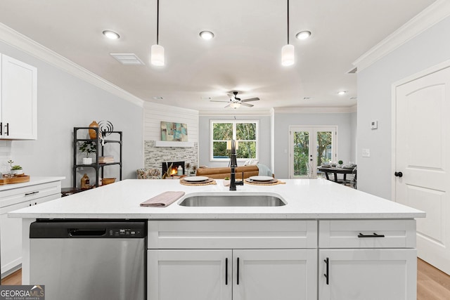 kitchen with white cabinetry, dishwasher, sink, and hanging light fixtures