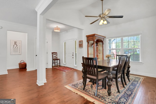 dining area with crown molding, vaulted ceiling, decorative columns, dark hardwood / wood-style flooring, and ceiling fan