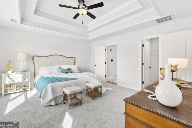 carpeted bedroom featuring a walk in closet, ceiling fan, and a raised ceiling