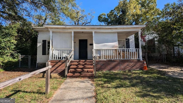 bungalow with covered porch and a front lawn