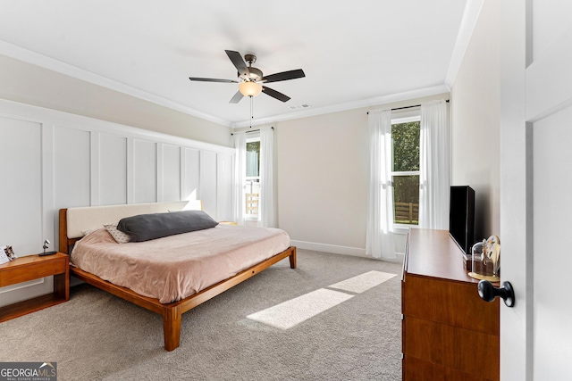 carpeted bedroom featuring crown molding and ceiling fan