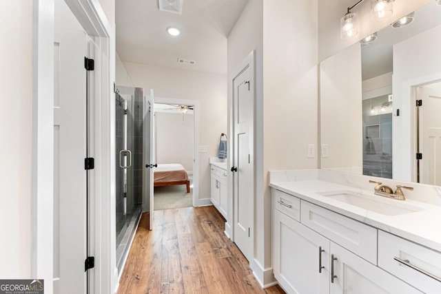 bathroom featuring vanity, ceiling fan, a shower with door, and hardwood / wood-style floors