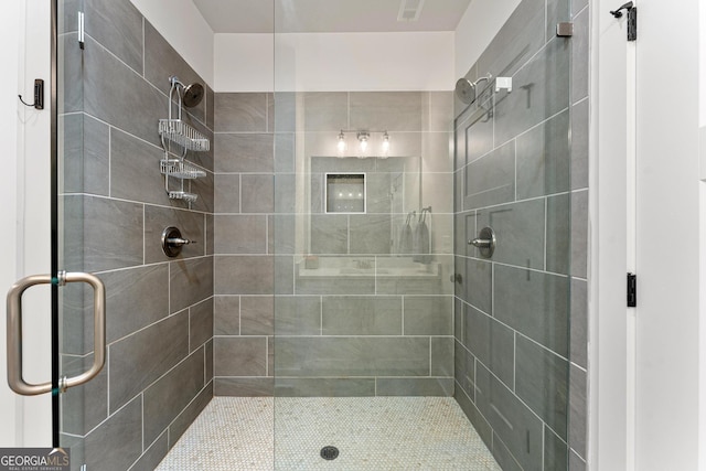 bathroom featuring a shower with door