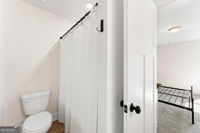 bathroom featuring a shower with shower curtain and toilet