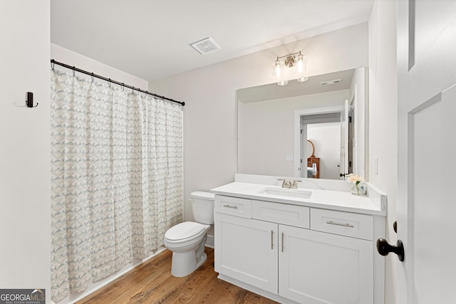 bathroom featuring vanity, hardwood / wood-style floors, a shower with curtain, and toilet