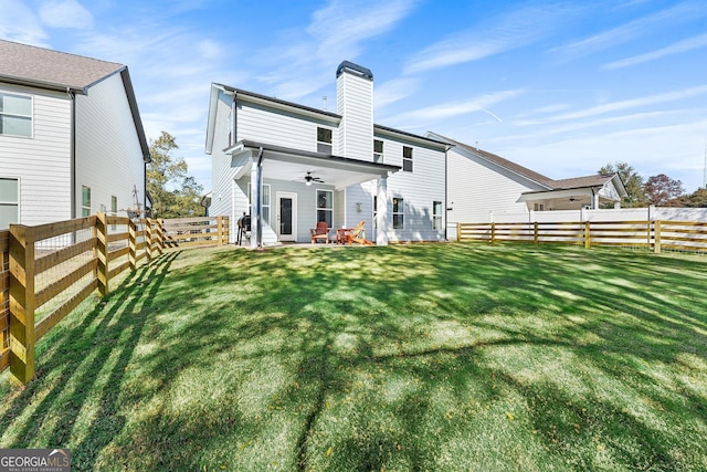 rear view of property featuring a patio area, a lawn, and ceiling fan