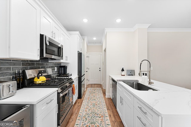 kitchen featuring white cabinetry, stainless steel appliances, light hardwood / wood-style flooring, and sink