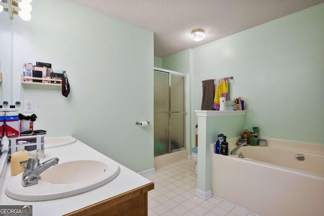 full bathroom with vanity, toilet, a textured ceiling, and shower with separate bathtub