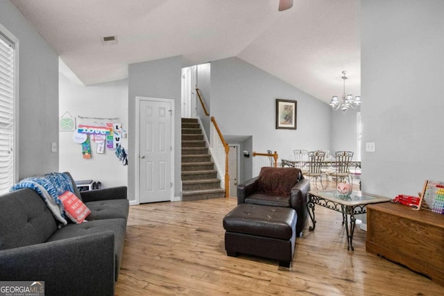 living room featuring light hardwood / wood-style flooring, a notable chandelier, and lofted ceiling