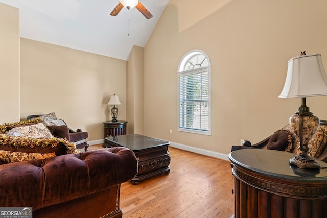 living room featuring high vaulted ceiling, light wood-type flooring, and ceiling fan