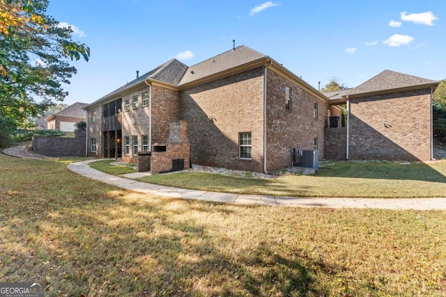 back of property with central AC and a yard