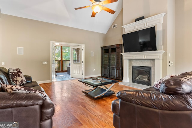 living room featuring light hardwood / wood-style flooring, high vaulted ceiling, and ceiling fan