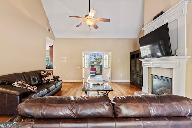 living room with light hardwood / wood-style floors, high vaulted ceiling, and ceiling fan