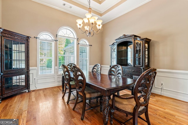 dining space with ornamental molding, a chandelier, and light wood-type flooring