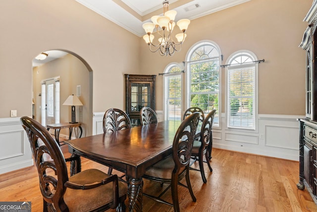 dining area featuring an inviting chandelier, crown molding, and light hardwood / wood-style floors