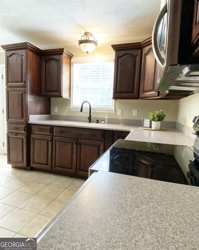 108 Sunset Dr, Dublin, GA 31027 - kitchen with stainless steel microwave, dark brown cabinets, light countertops, and a sink