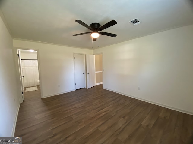 unfurnished bedroom with a closet, crown molding, ceiling fan, and dark hardwood / wood-style flooring