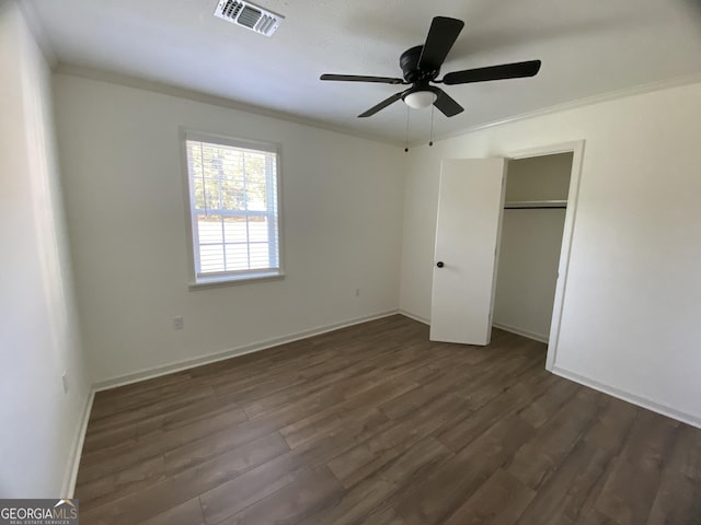 108 Sunset Dr, Dublin, GA 31027 - unfurnished bedroom with a closet, ornamental molding, visible vents, a ceiling fan, and dark wood-type flooring