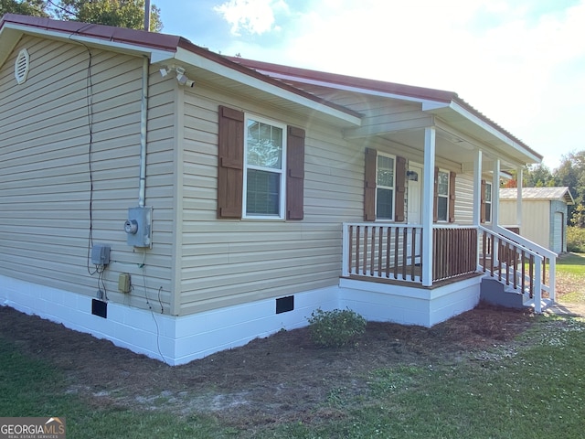 view of side of home featuring covered porch