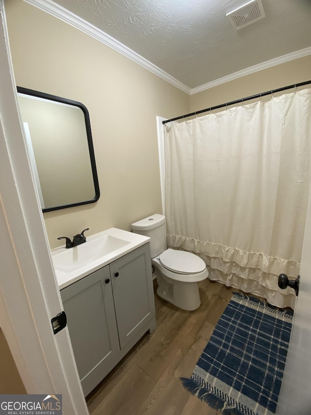 108 Sunset Dr, Dublin, GA 31027 - full bathroom featuring vanity, crown molding, toilet, visible vents, and wood finished floors