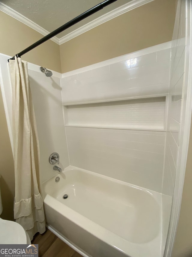 bathroom featuring toilet, ornamental molding, shower / bath combination with curtain, and hardwood / wood-style floors