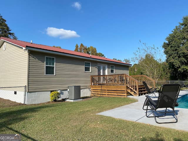 rear view of property featuring a yard, a deck, central AC unit, and a patio