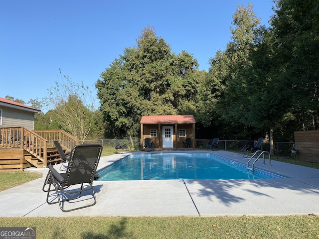 108 Sunset Dr, Dublin, GA 31027 - view of swimming pool with a patio area, an outdoor structure, a fenced in pool, a deck, and fence
