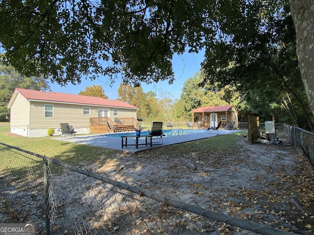 108 Sunset Dr, Dublin, GA 31027 - exterior space with a wooden deck, an outdoor structure, metal roof, a fenced in pool, and a fenced backyard