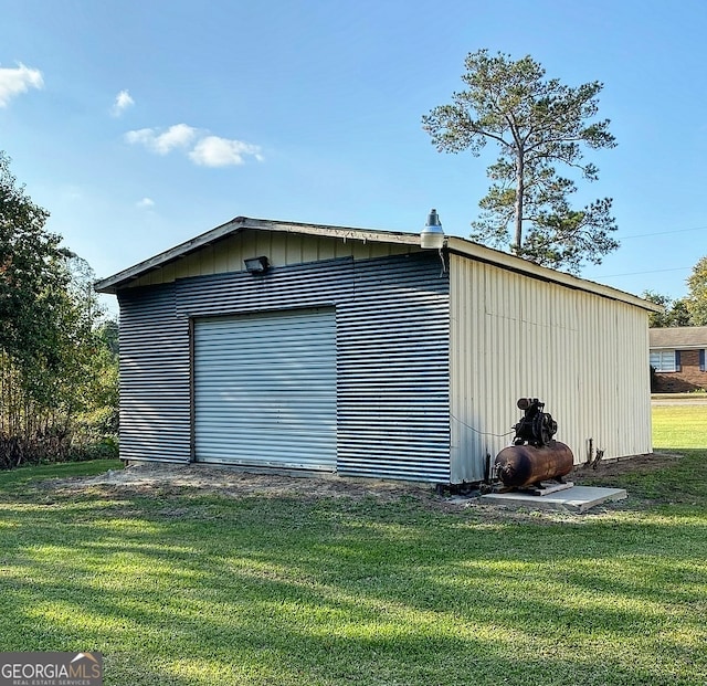 view of outbuilding with a garage and a lawn