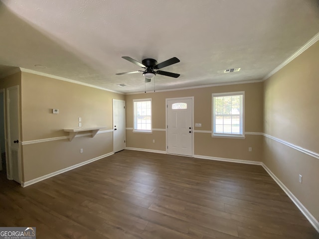 foyer with ceiling fan, a healthy amount of sunlight, crown molding, and dark hardwood / wood-style floors