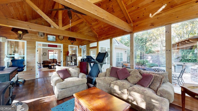 living room featuring vaulted ceiling with beams, wooden walls, a ceiling fan, wood ceiling, and dark wood finished floors