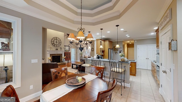 dining area featuring a notable chandelier, recessed lighting, ornamental molding, light tile patterned flooring, and a stone fireplace