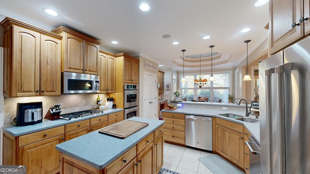 kitchen with stainless steel appliances, a sink, light countertops, backsplash, and pendant lighting