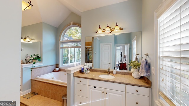 bathroom with lofted ceiling, a garden tub, vanity, and tile patterned floors