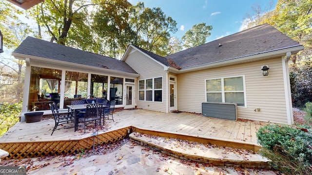 rear view of house featuring a shingled roof, outdoor dining area, and a deck