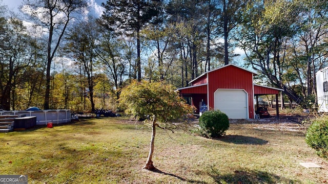 view of yard with an outbuilding, a detached garage, driveway, an outdoor pool, and a carport