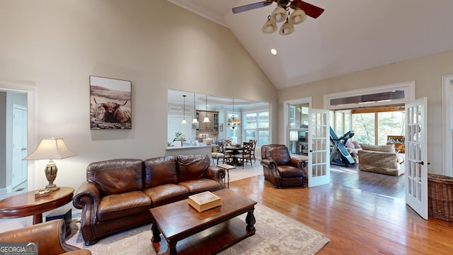 living room with plenty of natural light, high vaulted ceiling, wood finished floors, and french doors