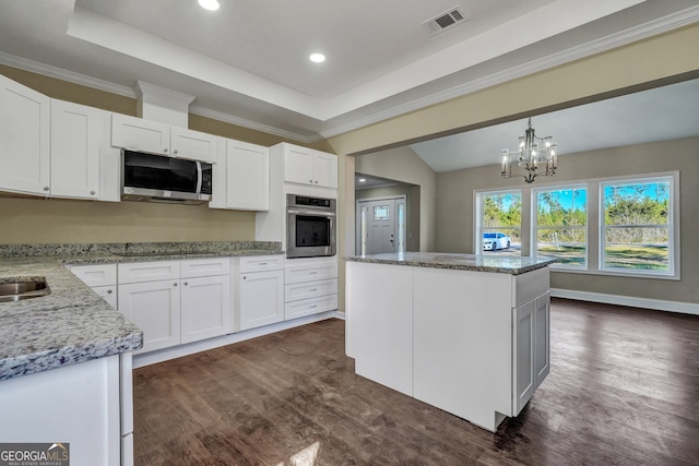 kitchen featuring appliances with stainless steel finishes, white cabinetry, dark wood-type flooring, and a kitchen island