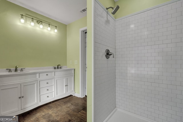 bathroom with vanity, hardwood / wood-style floors, and tiled shower