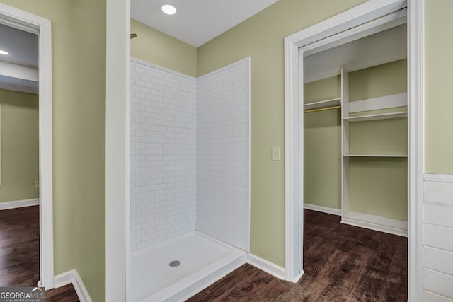 bathroom with a tile shower and hardwood / wood-style floors