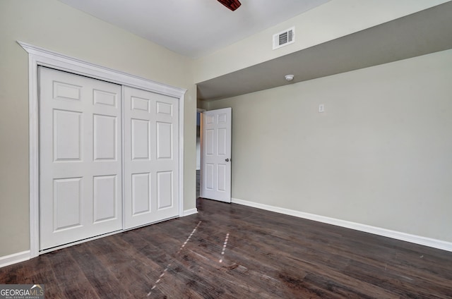 unfurnished bedroom with a closet and dark hardwood / wood-style flooring