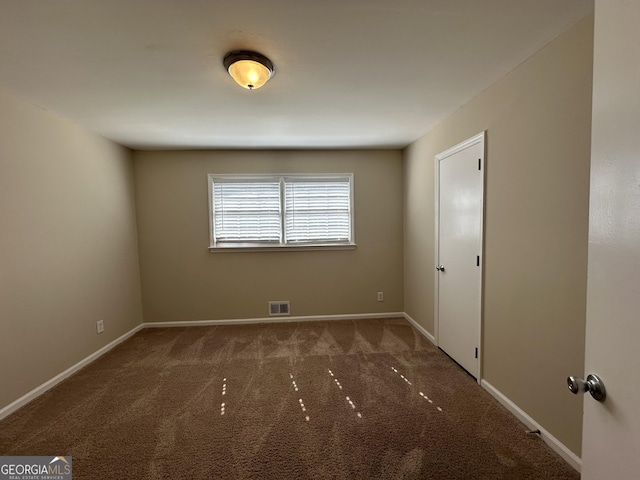 empty room featuring baseboards, visible vents, and carpet