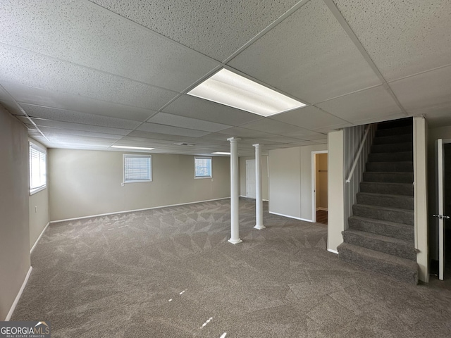 below grade area with carpet floors, stairs, a drop ceiling, and a wealth of natural light