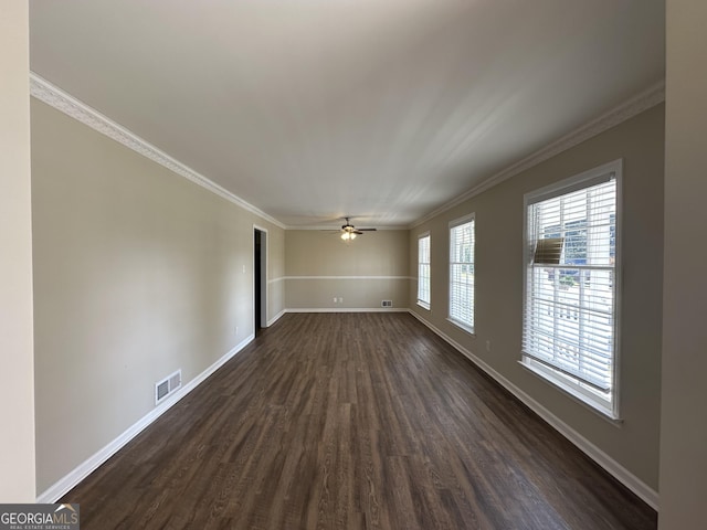 unfurnished room with crown molding, baseboards, dark wood-style flooring, and visible vents