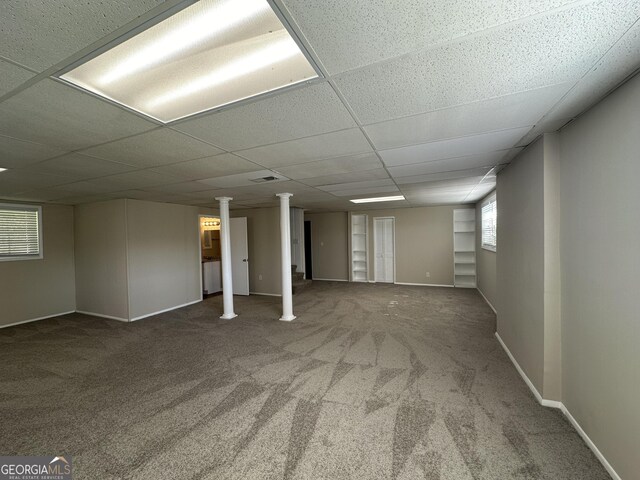 basement with carpet floors, baseboards, and a drop ceiling