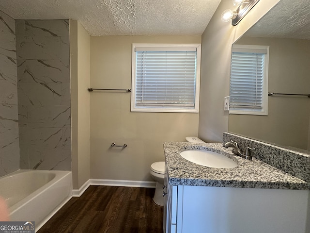 full bath with a textured ceiling, wood finished floors, baseboards, vanity, and toilet
